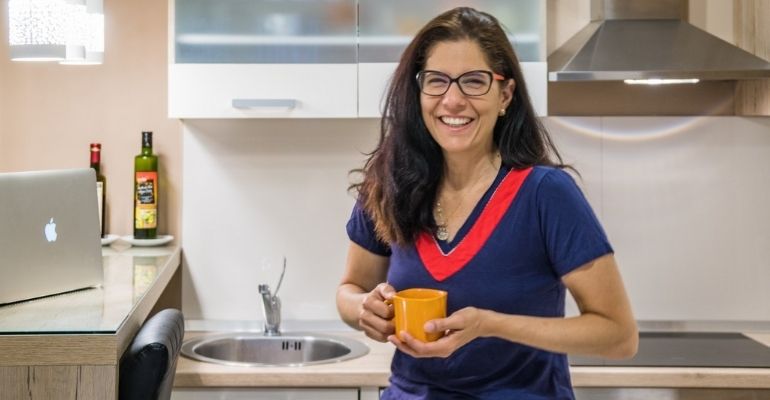 Patricia Figueira do Casal Partiu em uma cozinha de apartamento do Airnbnb. Nômades digitais